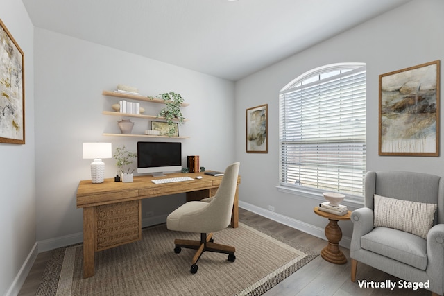 office area with a healthy amount of sunlight, baseboards, and wood finished floors