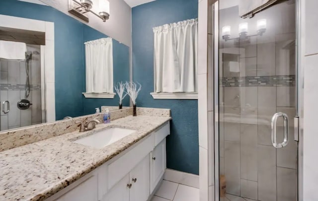 bathroom with a stall shower, tile patterned flooring, vanity, and baseboards