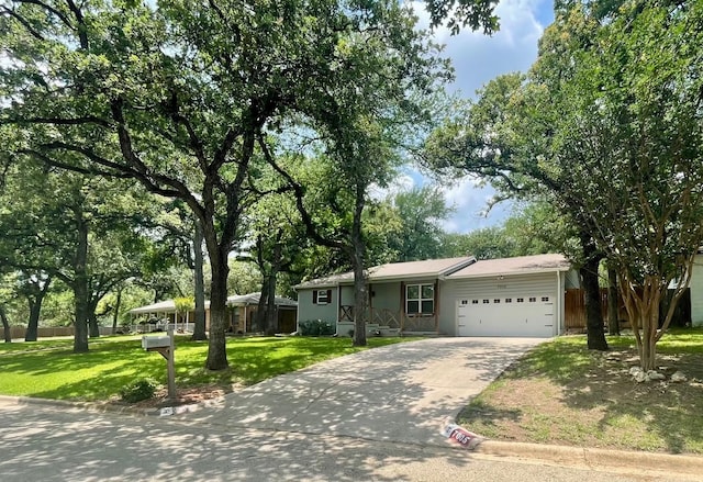 ranch-style house with a garage, fence, concrete driveway, and a front yard