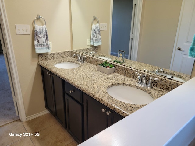 full bathroom with double vanity, a sink, and tile patterned floors