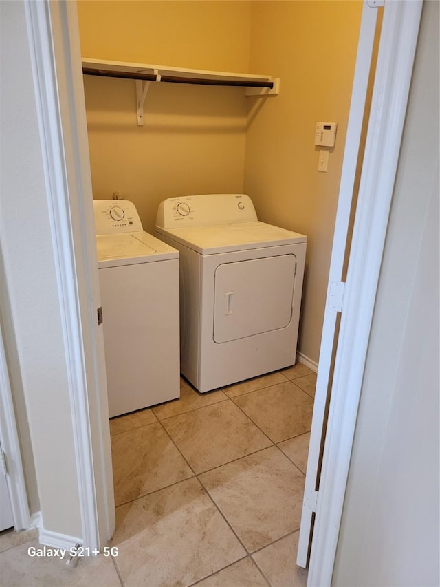 laundry area with laundry area, light tile patterned floors, and washing machine and clothes dryer