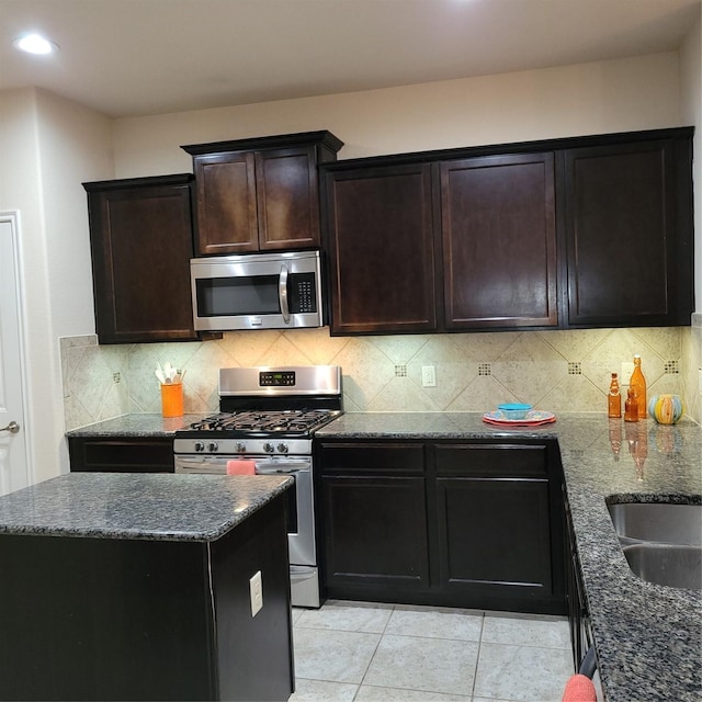 kitchen featuring tasteful backsplash, dark stone countertops, light tile patterned flooring, stainless steel appliances, and recessed lighting