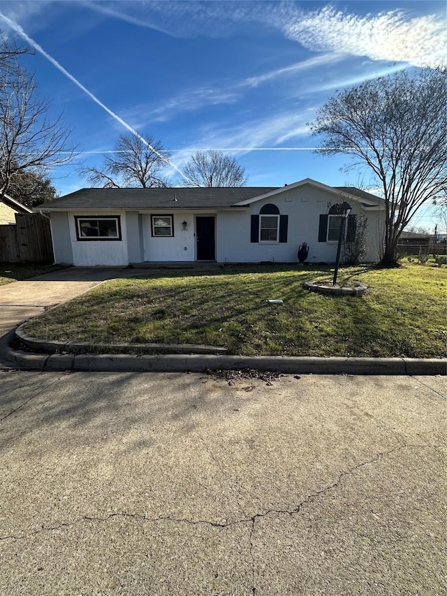 ranch-style house featuring fence and a front lawn