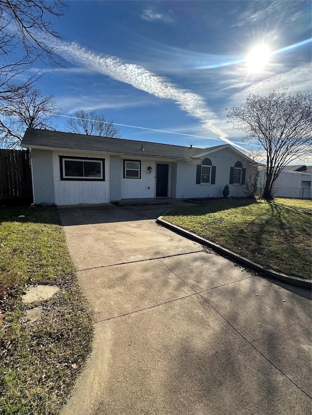 ranch-style home featuring a front yard and fence