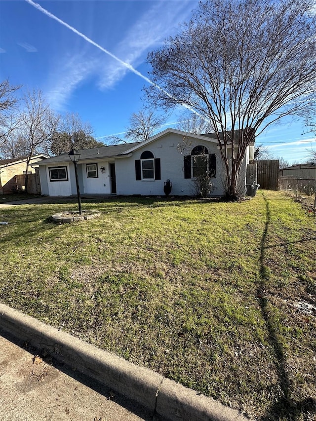 ranch-style home featuring a front yard and fence