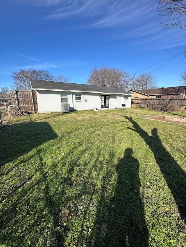 exterior space with central AC and a fenced backyard