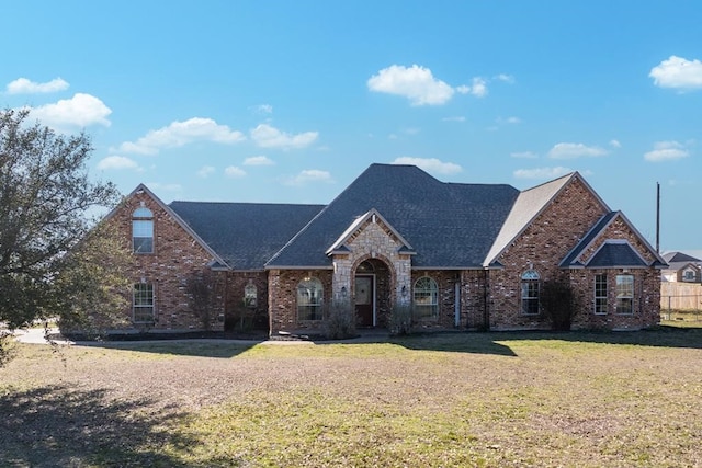 traditional home with brick siding and a front lawn