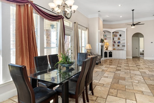 dining room with arched walkways, crown molding, stone tile flooring, and baseboards