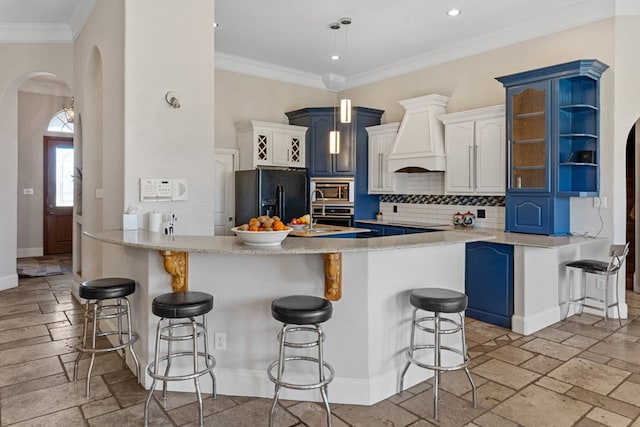 kitchen featuring arched walkways, a peninsula, black refrigerator with ice dispenser, stainless steel microwave, and stone tile flooring