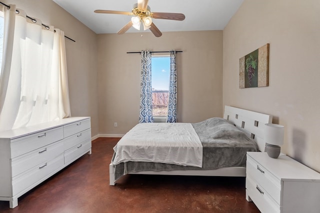 bedroom featuring a ceiling fan, finished concrete flooring, and baseboards