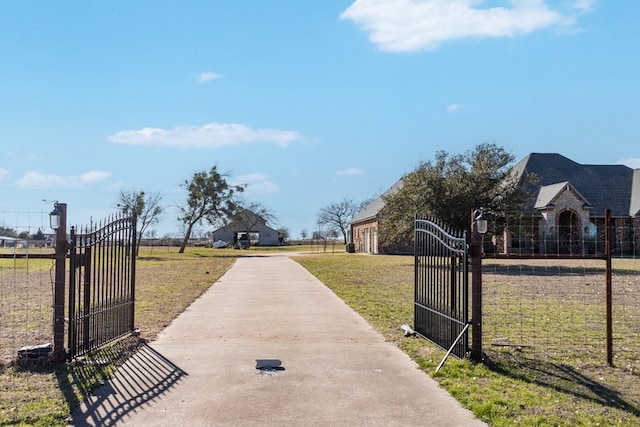 view of street with a gate, a gated entry, and concrete driveway