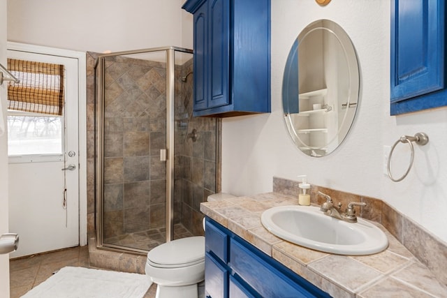 bathroom with a shower stall, toilet, and vanity