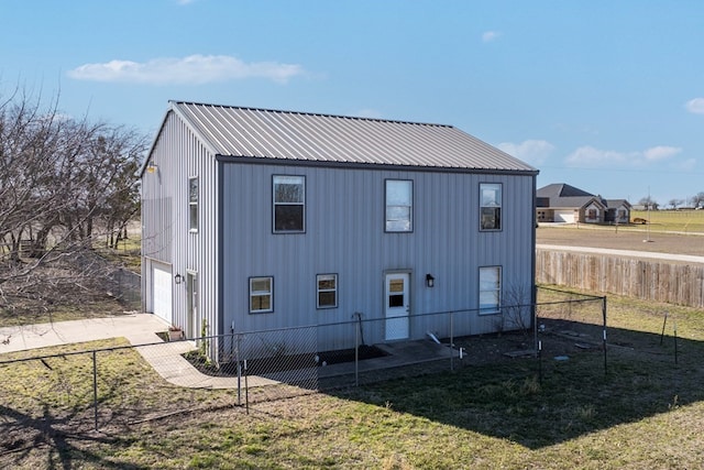 view of outdoor structure featuring a garage, fence, and concrete driveway