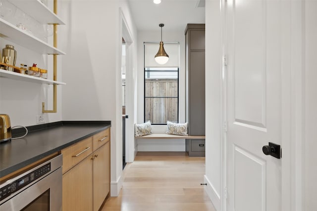 interior space with light wood-style flooring, pendant lighting, recessed lighting, and built in microwave