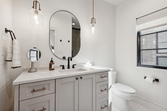 bathroom featuring baseboards, vanity, tile patterned flooring, and toilet