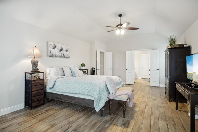 bedroom featuring light wood-type flooring, baseboards, a ceiling fan, and vaulted ceiling