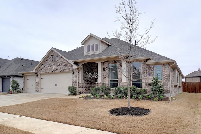 view of front facade with a front lawn, driveway, roof with shingles, a garage, and brick siding