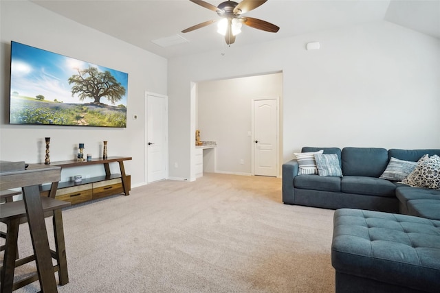 living area featuring a ceiling fan, vaulted ceiling, light colored carpet, and baseboards