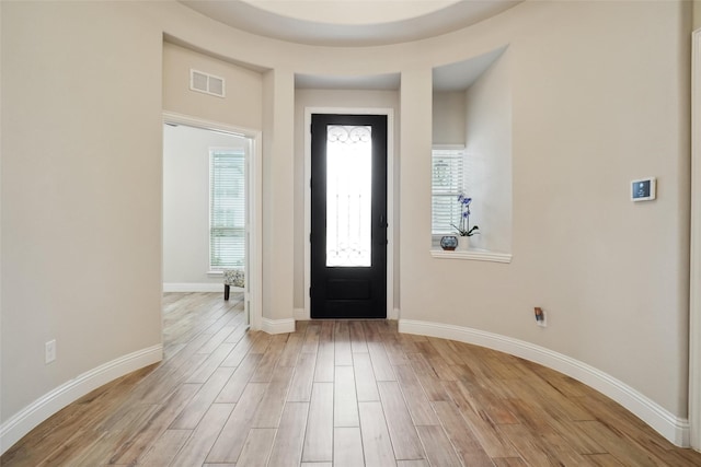 foyer entrance with visible vents, baseboards, and light wood-style floors