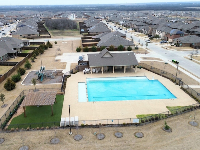 view of swimming pool featuring a patio area, fence, and a residential view