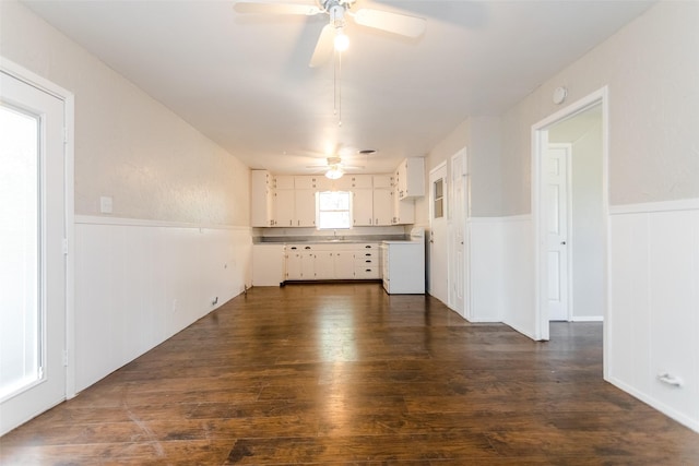 interior space featuring ceiling fan, dark wood-type flooring, a sink, wainscoting, and washer / dryer