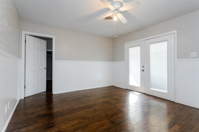 unfurnished room with a wainscoted wall, visible vents, hardwood / wood-style flooring, and french doors