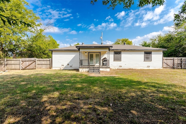 rear view of house featuring a yard, a fenced backyard, and a gate