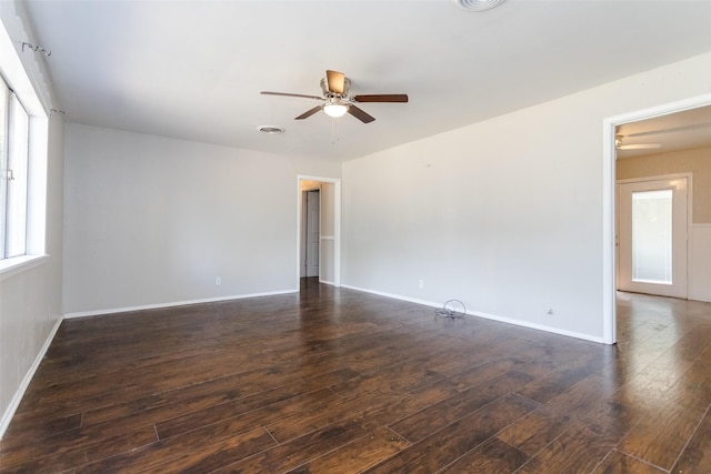 spare room featuring wood-type flooring, visible vents, baseboards, and ceiling fan