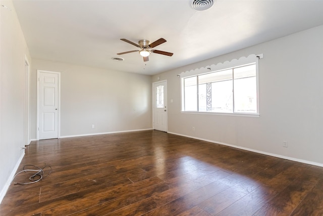 spare room featuring a ceiling fan, wood-type flooring, visible vents, and baseboards