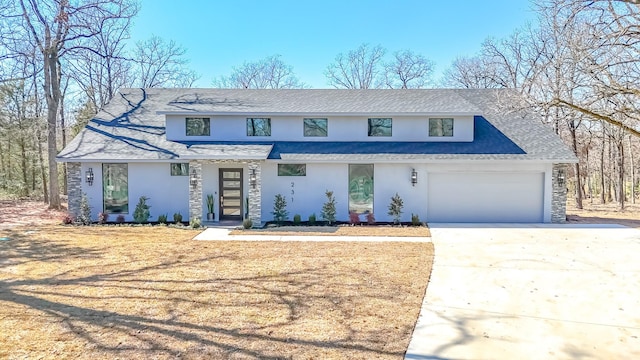 view of front facade with stucco siding, driveway, and an attached garage