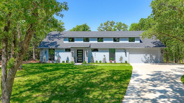traditional home featuring stucco siding, a garage, a front lawn, and concrete driveway