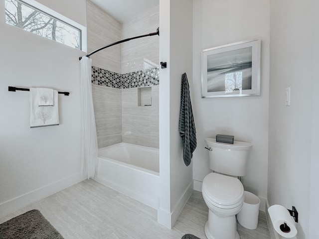 bathroom featuring shower / bath combination with curtain, baseboards, and toilet