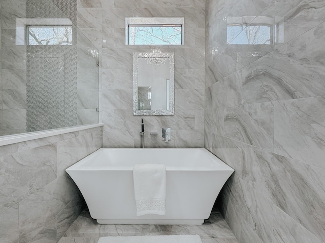 bathroom with tile walls and a soaking tub