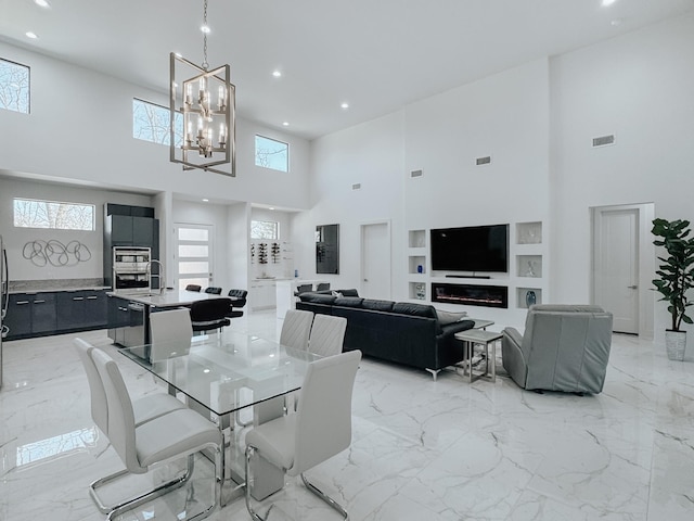 dining area with marble finish floor, a high ceiling, recessed lighting, and built in features