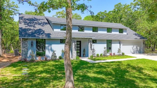 view of front of house with an attached garage, driveway, a front lawn, and stucco siding