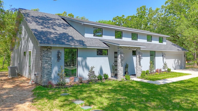 view of front facade featuring a garage, central air condition unit, a front lawn, and stucco siding