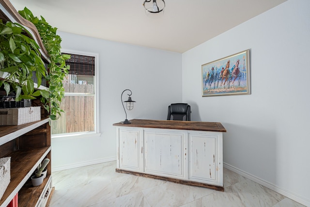 office space with marble finish floor and baseboards