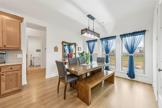 dining room with light wood-type flooring and baseboards