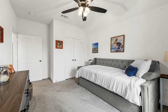 bedroom featuring visible vents, ceiling fan, vaulted ceiling, carpet flooring, and a closet