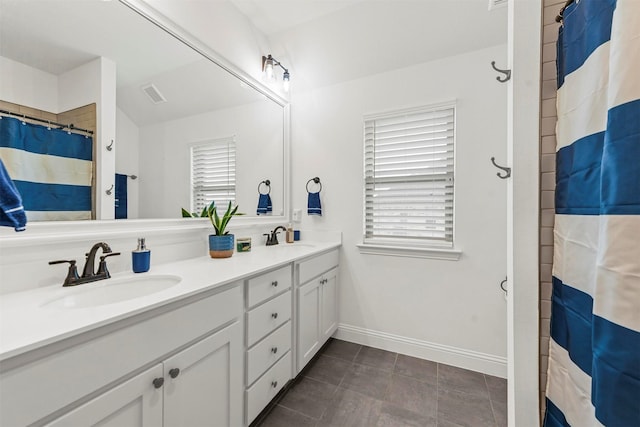 bathroom featuring visible vents, a sink, baseboards, and double vanity