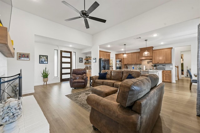 living area featuring recessed lighting, ceiling fan, baseboards, and wood finished floors