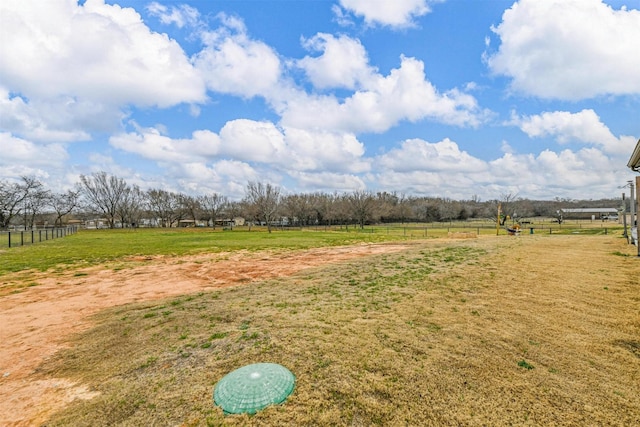 view of yard featuring a rural view and fence