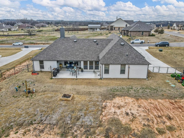 rear view of property with a shingled roof, a residential view, a fenced backyard, and a patio