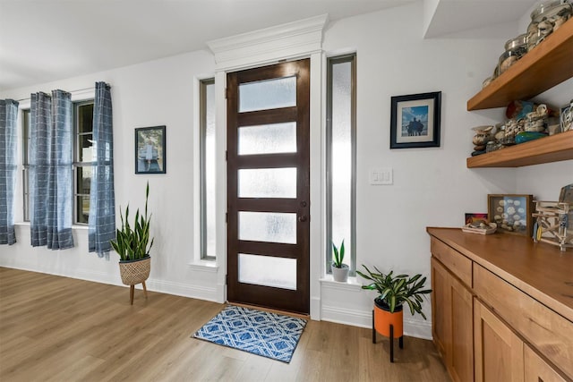 entryway with light wood finished floors, plenty of natural light, and baseboards