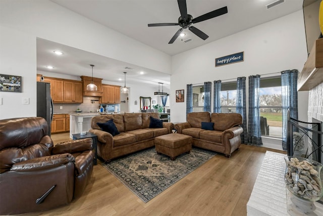 living room with light wood finished floors, visible vents, a ceiling fan, and recessed lighting