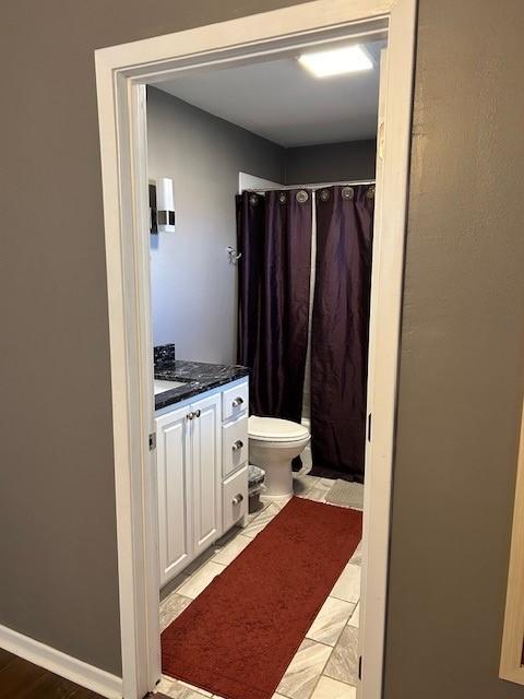 909 Harwell St, Abilene, TX 79601 - full bath with toilet, curtained shower, vanity, and baseboards