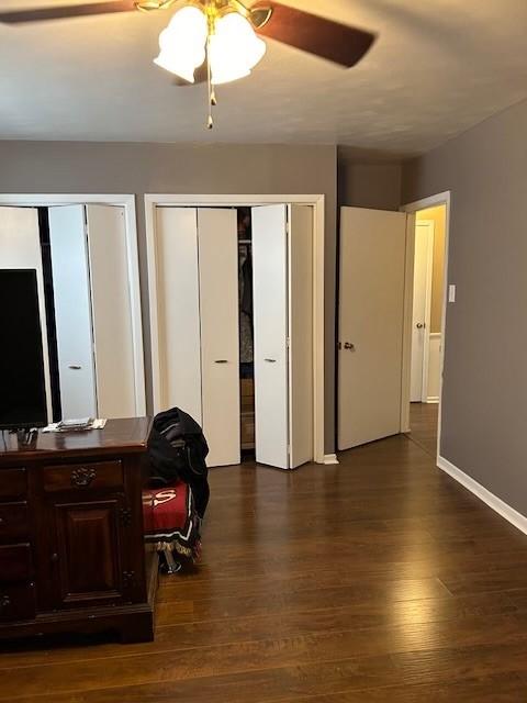 909 Harwell St, Abilene, TX 79601 - bedroom with multiple closets, dark wood-type flooring, baseboards, and a ceiling fan