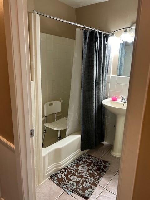 909 Harwell St, Abilene, TX 79601 - full bathroom with shower / tub combo, a sink, tile walls, and tile patterned floors