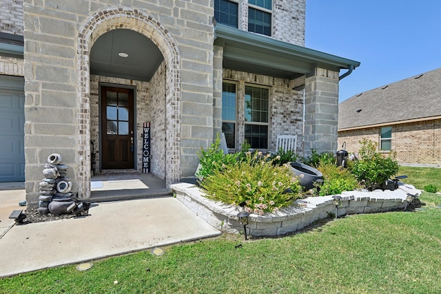 doorway to property featuring a garage and stone siding