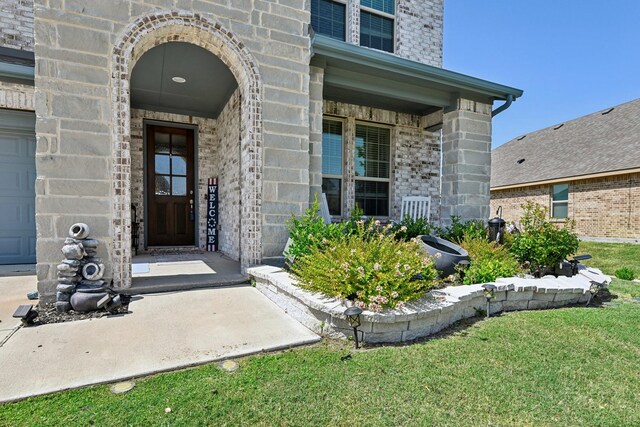 view of front facade with brick siding, central AC unit, a garage, stone siding, and driveway